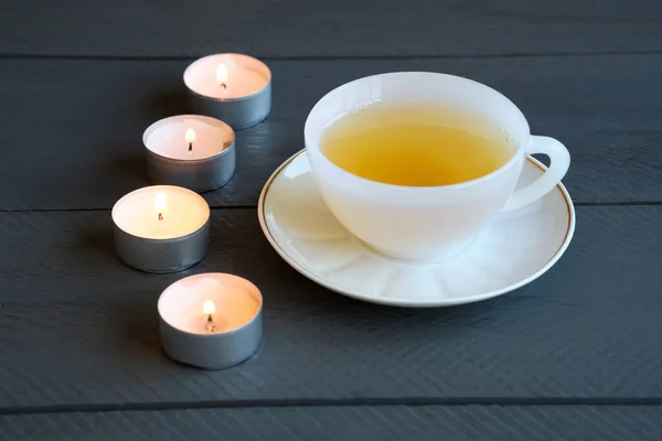 Ένα Φλιτζάνι Πράσινο Τσάι Και Κεριά Μαύρο Ξύλινο Τραπέζι — Φωτογραφία Αρχείου