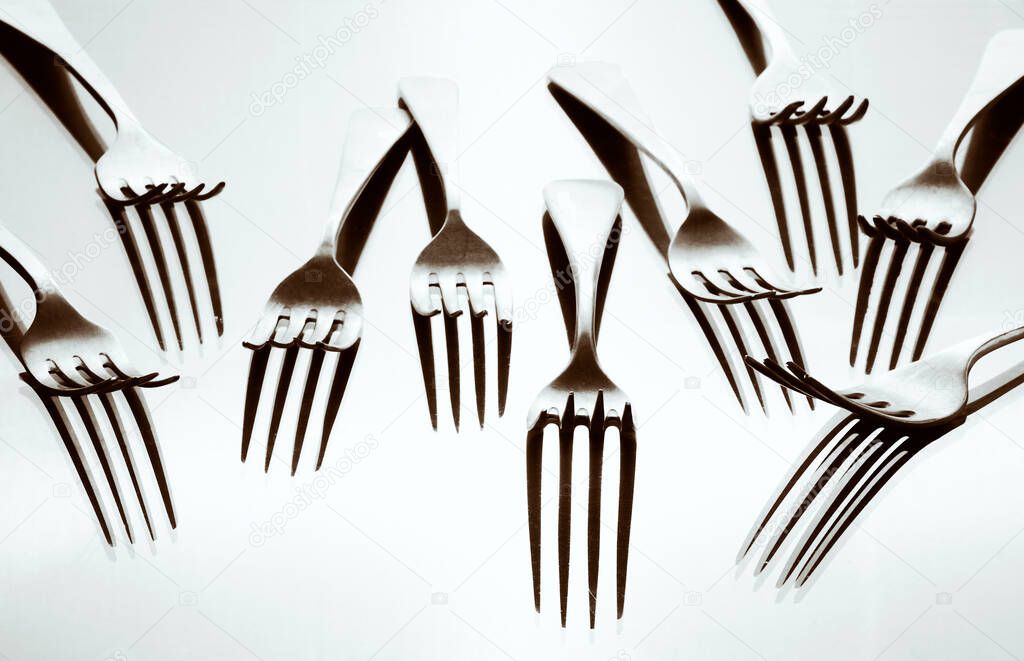 forks haphazardly placed and illuminated to create different shades and selenium toning tone