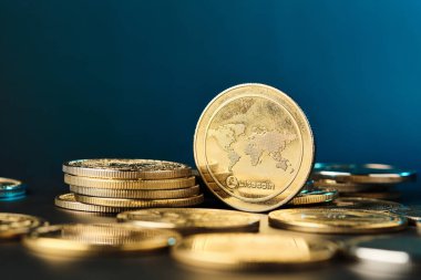 Önde gelen bir Litecoin madeni parası, altın tonlarını vurgulayan çarpıcı mavi bir arka planla diğer madeni paralar arasında parlak bir şekilde parlar..