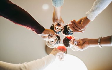 Restoranda doğum günü kutlamaları sırasında şarap kadehleriyle tezahürat yapan bir grup genç.