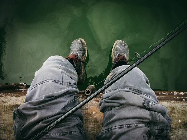 Legs Fisherman Sitting Dirty Rubber Boots Bank River Green Water — Stock Photo, Image