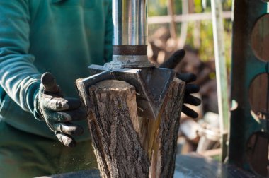 Adam odun kesmek için elektrikli testere kullanıyor.