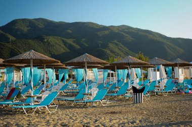Covid 19 virüsü salgını sırasında tahta şemsiyeli ve güneşli plaj. Coronavirüs 'ün yayılması ve turizm sektörünün krizi kavramı