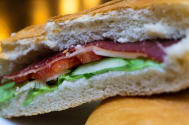 Restorandaki ahşap masada füme jambonlu Sırp sandviçi.