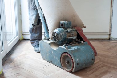 Zemini zımparalama makinesiyle zımparalıyorum. Apartmanda tamirat var. Marangoz parke ahşap parke döşeme bakım işi yapıyor.