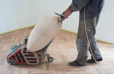 Zemini zımparalama makinesiyle zımparalıyorum. Apartmanda tamirat var. Marangoz parke ahşap parke döşeme bakım işi yapıyor.