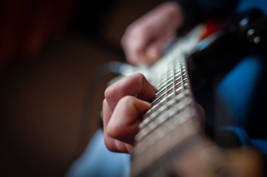 Gitarist gitar çalar. Ellerine odaklan. Elektro gitar çalan genç adam.