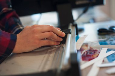 İşçi kağıt kesiciyle kağıt keser.