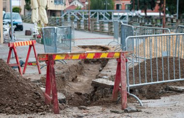 Şehir caddesinin yeniden inşası. Atmosferik kanalizasyon düzeni. Eski kanalizasyon borularının değiştirilmesi nedeniyle sokağın kazılan kısmında koruma çiti ve uyarı işaretleri var..