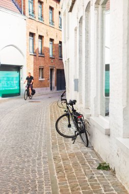Bir kaldırım taşları ile evin duvarında Bisiklet pahasına. Caddenin antik kentin Avrupa, dar sokağa mesafe adam bisikletle gidiyor. Bu renkli