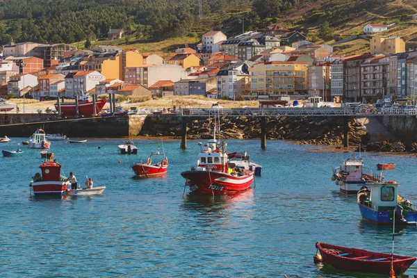 Laxe, İspanya - 14 Temmuz 2016: Körfez'de bulunan Galiçya yerleşim, balıkçıların tekneler. Yaz güneşli gün, sakin. Ön planda mesafe sahil ve evi çizgi tekneler