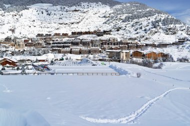 Kış günü bir alpine kayak yamacı köyden görünümünü. Bu güneşli soğuk bir günde kar çok