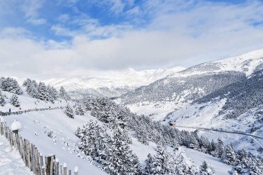 Kışın dağlarda Pyrenees, Andorra yamaçları görünümünü. Köknar orman kar ile kaplı yamaçlar üzerinde aşağıdaki yol görülür