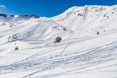 Pyrenees, Andorra kayak pistleri ile görünüm Dağı nın yamaçlarında. Hazırlanan yollar ve devreden izleri eteklerinde. Güneşli soğuk kış günü