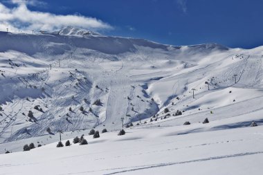 Pyrenees, Andorra kayak pistleri ile görünüm Dağı nın yamaçlarında. Hazırlanan yollar ve devreden izleri eteklerinde. Güneşli soğuk kış günü