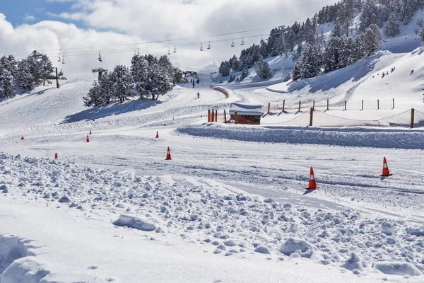 The route for test-drive cars in difficult conditions in the mountains - the Pyrenees, Andorra. The road is covered with snow, with descents and ascents, the road is marked by road cones.