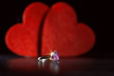 İki dekoratif kalp arka plan üzerine taşlı yüzük. Siyah arka plan, seçici odak, aşk kavramı