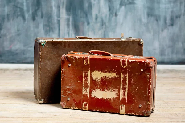 Dos maletas de color marrón malhumorado cerca de una pared oscura en tiza — Foto de Stock