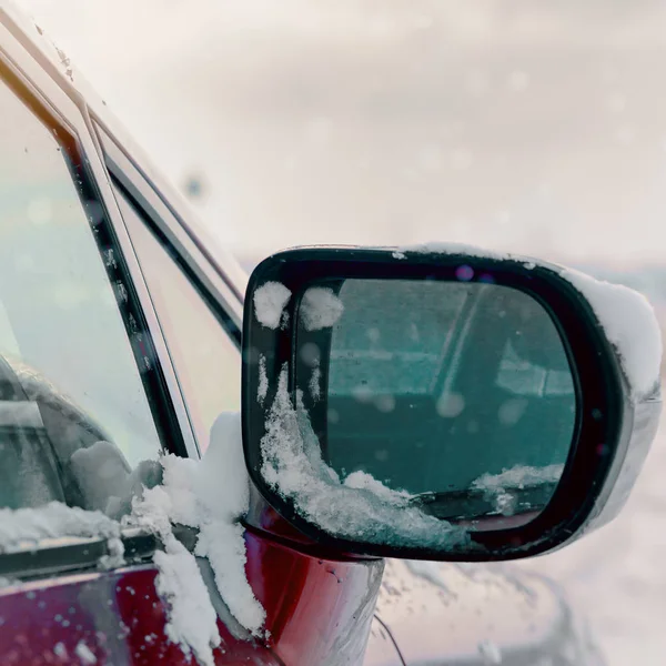 Ein Seitenspiegel eines Autos im Schnee an einem Wintertag — Stockfoto