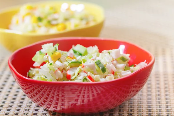 Salad with cucumbers and crabs in colored ceramic plates. Stock Image