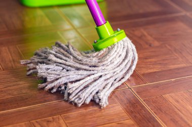 Rope mop wipes the floor of the tile. clipart