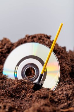 Bir kürek yanında toprağa gömülü Cd yarısıdır