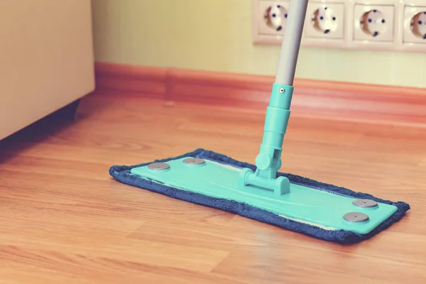 Blue mop on the floor of brown laminate — Stock Photo, Image