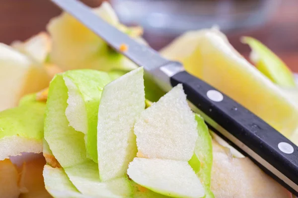Peelings green apple, pieces of peel and a knife lying on top. — Stock Photo, Image