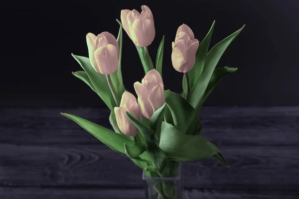 Um buquê de tulipas rosa em um fundo escuro, vista superior . — Fotografia de Stock