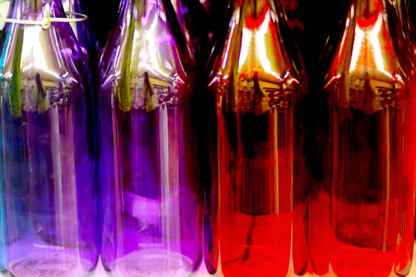 Bouteilles en verre multicolores sur l'étagère dans le magasin . — Photo