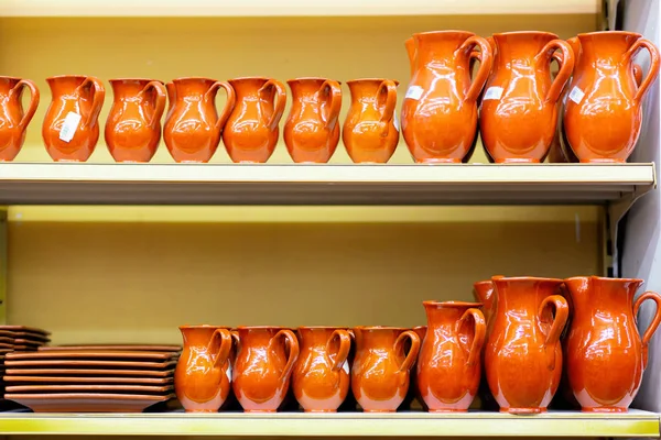 Keramiek servies kannen en platen zijn op de plank van de winkel. — Stockfoto
