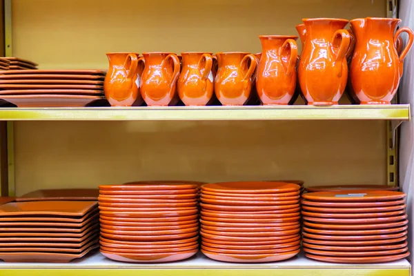 Keramiek servies kannen en platen zijn op de plank van de winkel. — Stockfoto