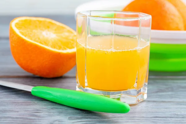 在木桌上的杯子里的鲜榨橙汁. — 图库照片