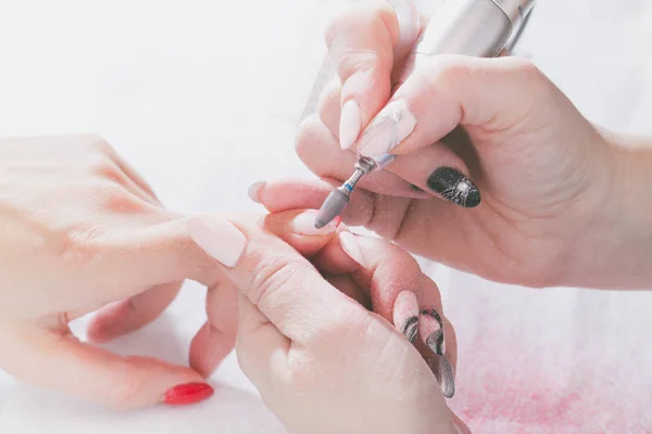 Las manos del maestro de la manicura y las manos del cliente de cerca durante el proceso de diseño de uñas . — Foto de Stock