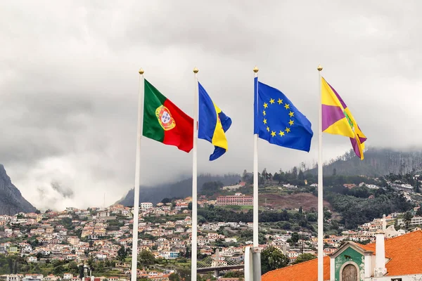 Banderas de Portugal, Madeira, la Unión Europea y Funchal en el contexto de los edificios de la ciudad de Funchal . — Foto de Stock