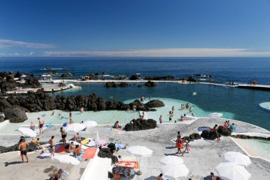 Porto Moniz, Madeira, Portekiz - 25 Temmuz 2018: Tatilciler güneşlenir ve lav havuzlarında yüzer