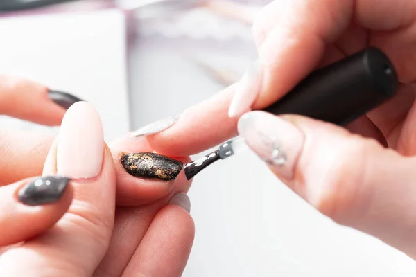 La aplicación de barniz en las uñas en la manicura en el salón . — Foto de Stock