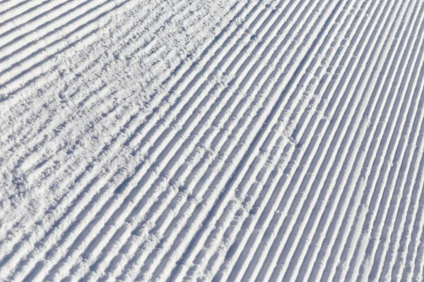 Neige sur les pistes de ski préparées journée ensoleillée d'hiver — Photo