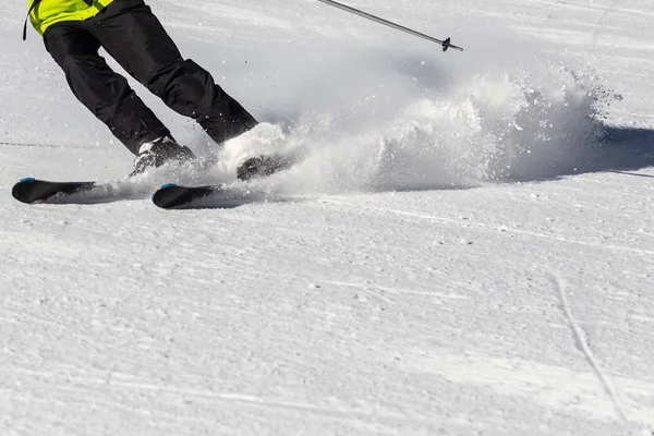 スキー場のスキーヤーは、スキーから雪の旋風で回ります. — ストック写真