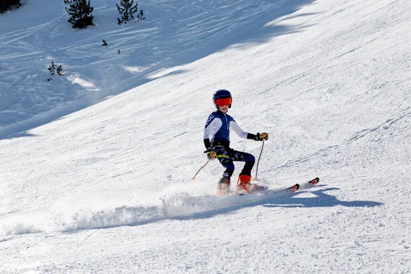 ピレネー山脈、アンドラ- 2019年2月16日:山の斜面にあるスラロームの制服を着た少年スキーが鋭いターンを作ります — ストック写真