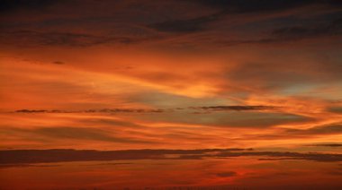 Turuncu gökyüzü ve muhteşem altın yansımasıyla güzel dramatik bir gün batımı. İnanılmaz yaz gün batımı manzarası.