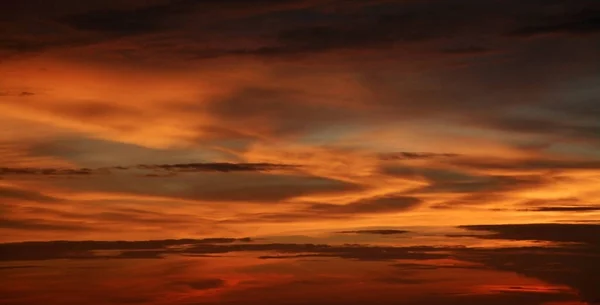 Schöner Dramatischer Sonnenuntergang Mit Orangefarbenem Himmel Und Atemberaubender Goldener Reflexion lizenzfreie Stockfotos