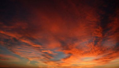 Turuncu gökyüzü ve muhteşem altın yansımasıyla güzel dramatik bir gün batımı. İnanılmaz yaz gün batımı manzarası.