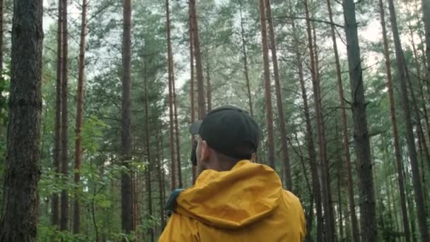 Мужчина-фотограф фотографирует в лесу осенью. — стоковое видео