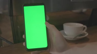 Yeşil ekranda akıllı telefon tutan bir kadın, teknoloji kavramı.