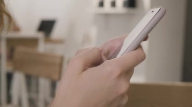 - Yakın çekim. Akıllı telefonuna mesaj yazan bir kadın. Kahve dükkanında..