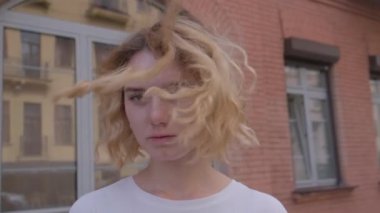 Arka planda genç bir kız Kırmızı tuğladan eski binalar.