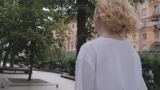 街中を歩く若いビジネスマンの女性のリアビュー。スローモーション. — ストック動画