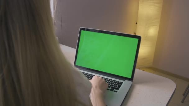 Πράσινη οθόνη σε φορητό υπολογιστή. Ένα νεαρό κορίτσι δακτυλογραφεί ένα μήνυμα ή ψάχνει. — Αρχείο Βίντεο