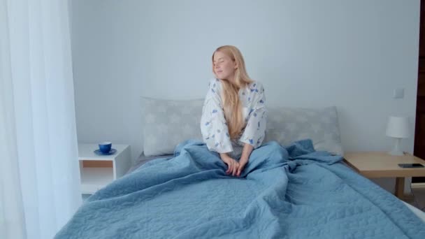 En ung flicka vaknar på morgonen och njuter av den vackra morgonen. — Stockvideo